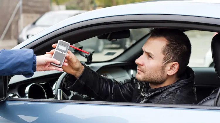 handsome man subjected breathalyzer test